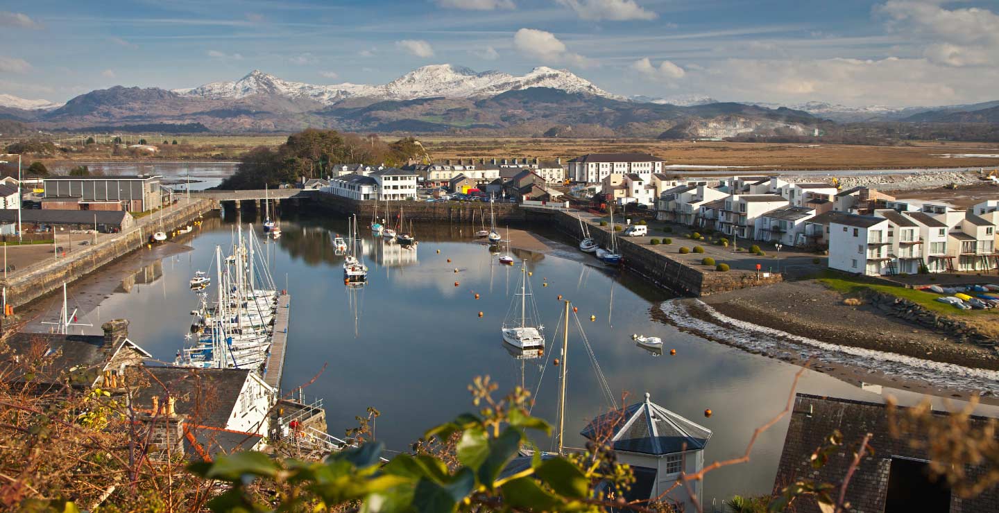 Harbour in winter with Moelwyn range covered in snow in background Porthmadog Gwynedd Snowdonia